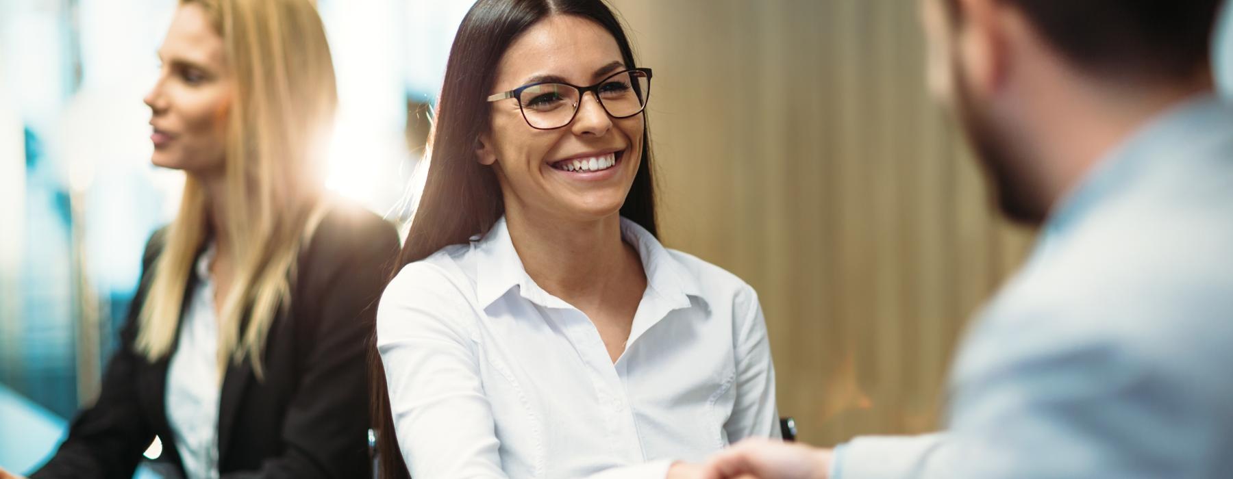 a person in a white shirt shaking hands with a business environment